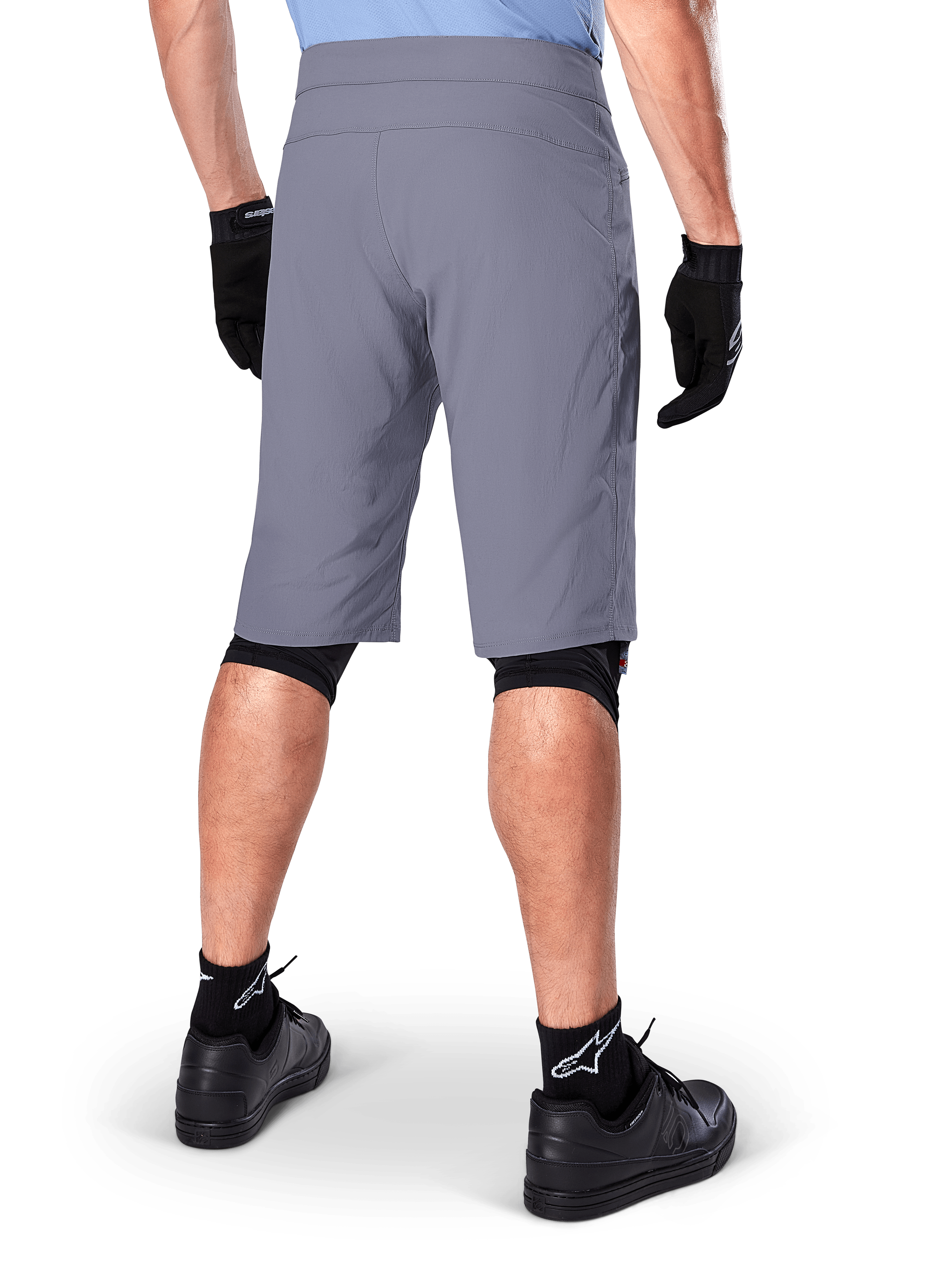 Alpinestars A-Dura Shorts, Dark Gray Mountain Bike Shorts, rear view shown on a rider, worn with black gloves, black knee liners, and black Alpinestars logo socks, durable construction for off-road cycling