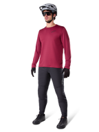 Alpinestars A-Dura Thermal Jersey in Burgundy, long-sleeve insulated cycling top worn with dark grey mountain bike pants, black gloves, and a grey helmet, full-body studio shot of cold-weather MTB gear.