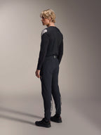 Alpinestars A-Aria Polartec Elite Jersey - Long Sleeve, Black, worn by a model from a back-side profile, featuring a white logo on the shoulder, paired with matching black cycling pants for a professional MTB outfit.
