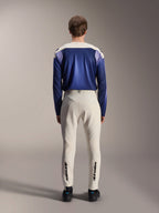Alpinestars A-Aria Polartec Maker Elite Long Sleeve Jersey, Baja Blue and off-white, back view of model wearing technical mountain bike gear including off-white pants with Alpinestars branding on the lower legs, performance cycling outfit for off-road trails
