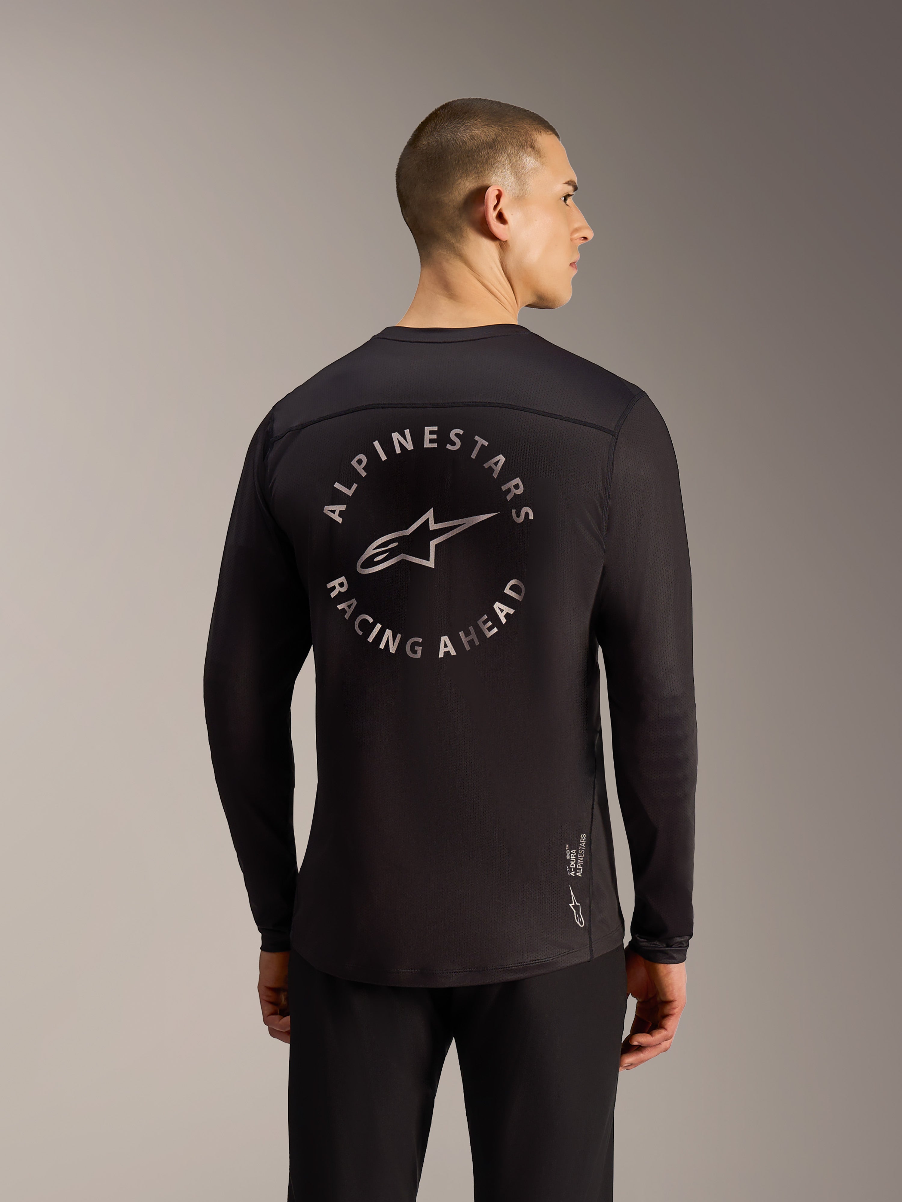 Black A-Dura Air LS Jersey back view featuring a circular Alpinestars Racing Ahead graphic and breathable mesh fabric.