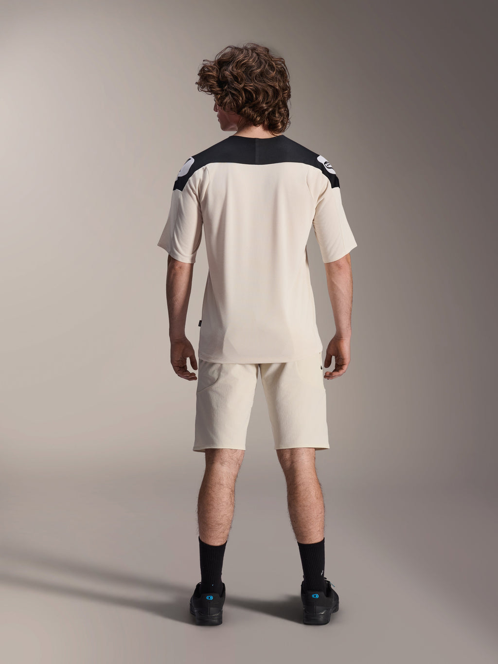 Alpinestars A-Aria Polartec Elite Short Sleeve Jersey, MTB Cycling Jersey, Ecru with black shoulder panels, back view shown with matching shorts and black socks, performance fit with a dropped tail design for off-road riding.