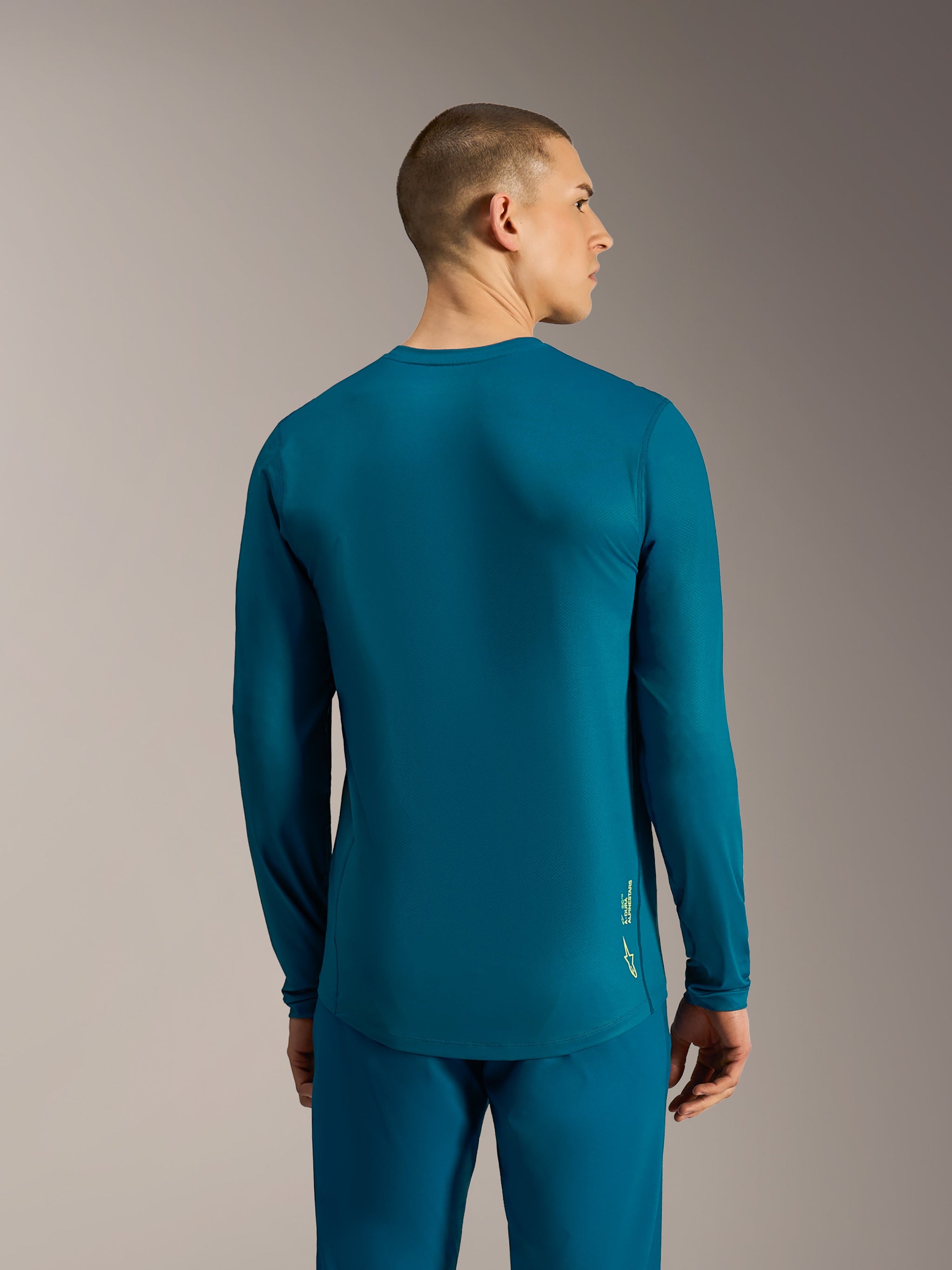 A-Dura Ride Long Sleeve Jersey in Blue Green, featuring a drop tail design and Alpinestars logo for performance MTB riding.