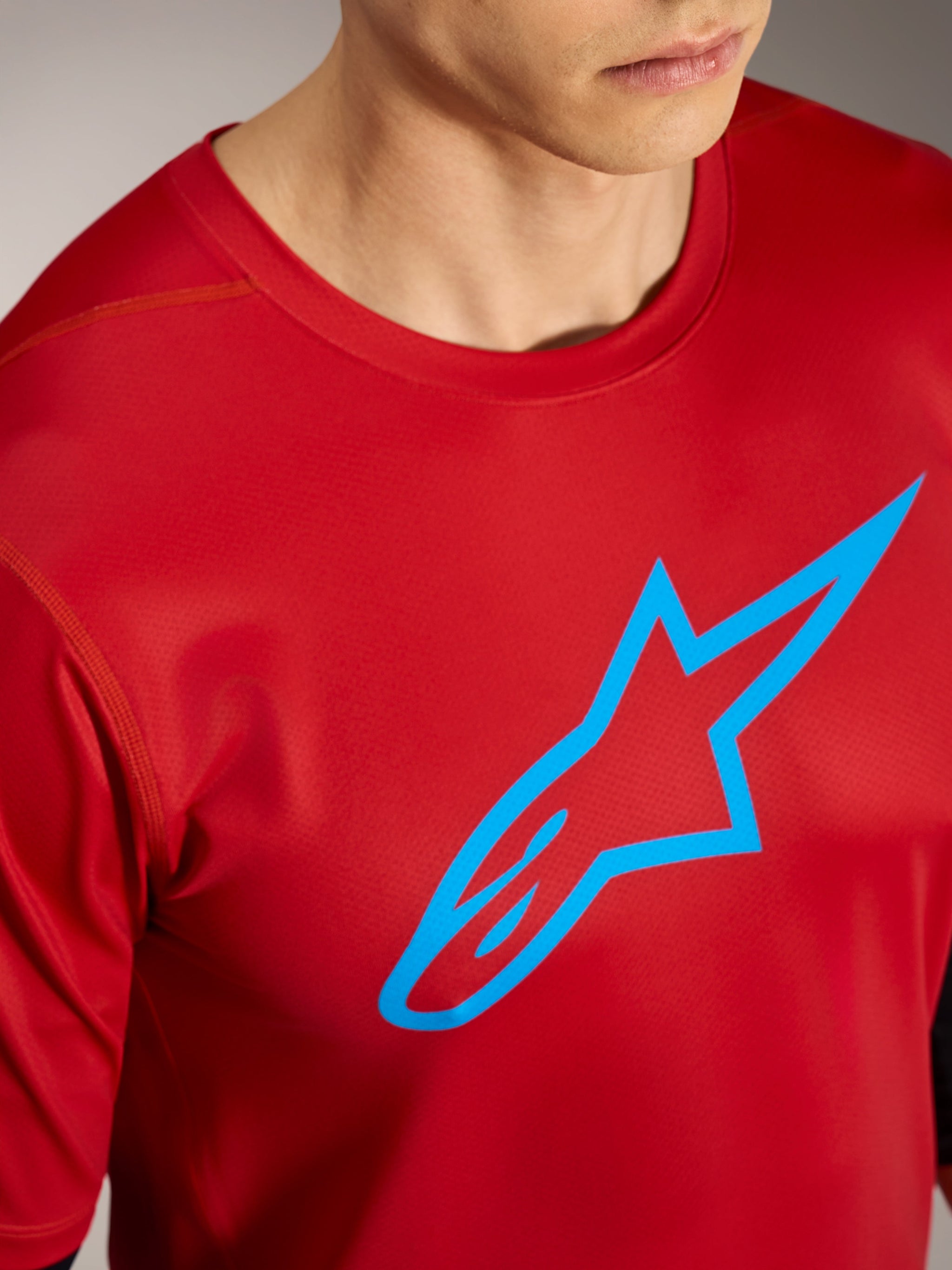 Red A-Dura Ride Short Sleeve Jersey featuring a blue Alpinestars logo, high-performance mountain bike apparel.