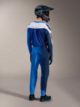 A-Supra Elite Jersey in Faded Bright Blue, rear view on a rider wearing full MTB racing gear and protective helmet.