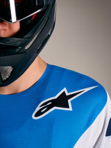 A-Supra Elite Jersey in Faded Bright Blue with Alpinestars logo on shoulder, worn with a full-face mountain bike helmet.