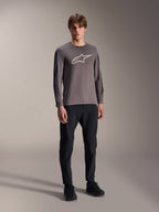 Alpinestars A-Dura Insert Astar Jersey, Long Sleeve MTB Jersey, Dark Gray, featuring large white chest logo, worn with black technical pants and black shoes, off-road cycling apparel