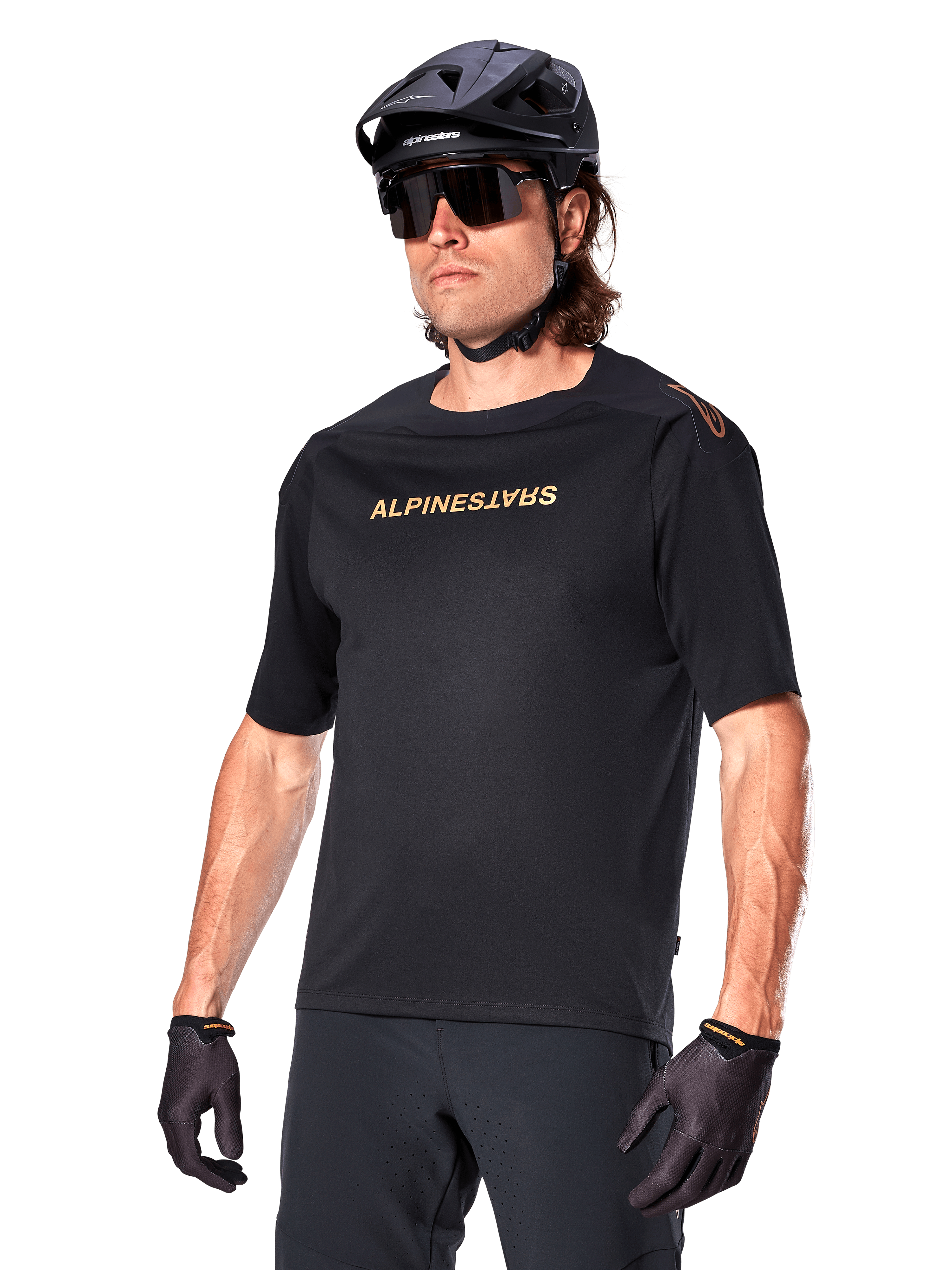 Alpinestars A-Aria Polartec Switch Jersey Short Sleeve, Black mountain bike jersey with gold Alpinestars branding, worn with black helmet, sunglasses, and gloves, technical MTB apparel