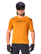 Alpinestars A-Aria Polartec Switch Jersey - Short Sleeve, Dark Gold, mountain bike rider wearing black helmet and sunglasses, performance cycling apparel for MTB trails