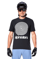 Alpinestars A-Dura Oscar Jersey, Short Sleeve MTB Jersey, Black, featuring a large white vintage Oscar spiral graphic on the chest, worn with a black cycling helmet, sunglasses, black gloves, and light blue shorts, heritage-inspired off-road cycling gear