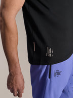Alpinestars A-Aria Switch Short Sleeve Jersey, Black MTB jersey, close-up of side hem with white 'ONE GOAL. ONE VISION.' branding, worn with light purple cycling shorts featuring matching logos