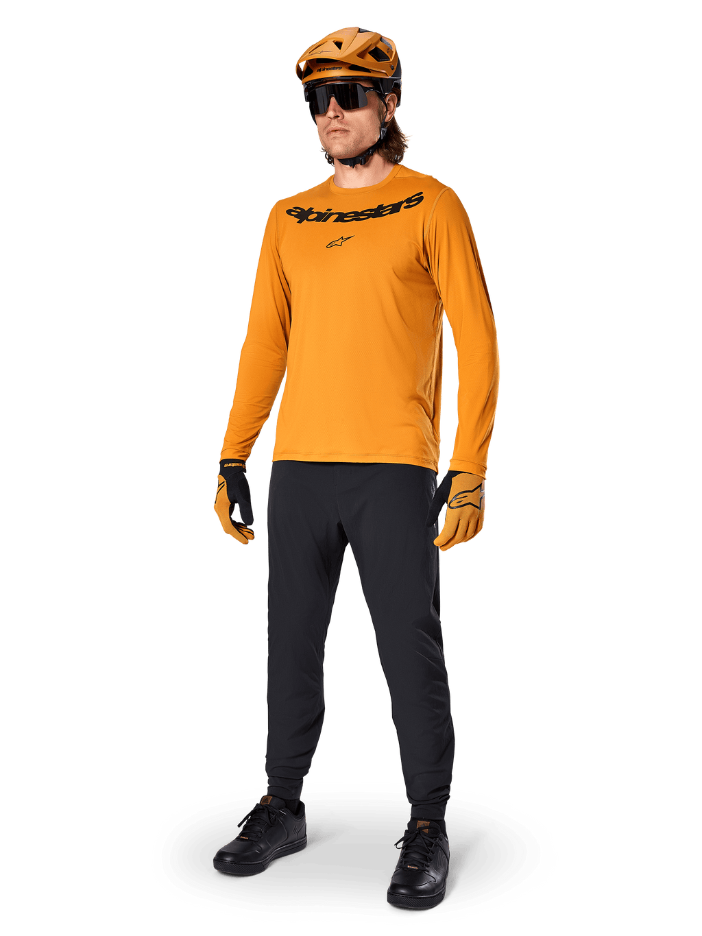 Alpinestars A-Dura Rocker Long Sleeve Jersey, Dark Gold cycling jersey, worn with matching MTB helmet and black pants, featuring black wordmark chest logo, coordinated performance gear for off-road mountain biking