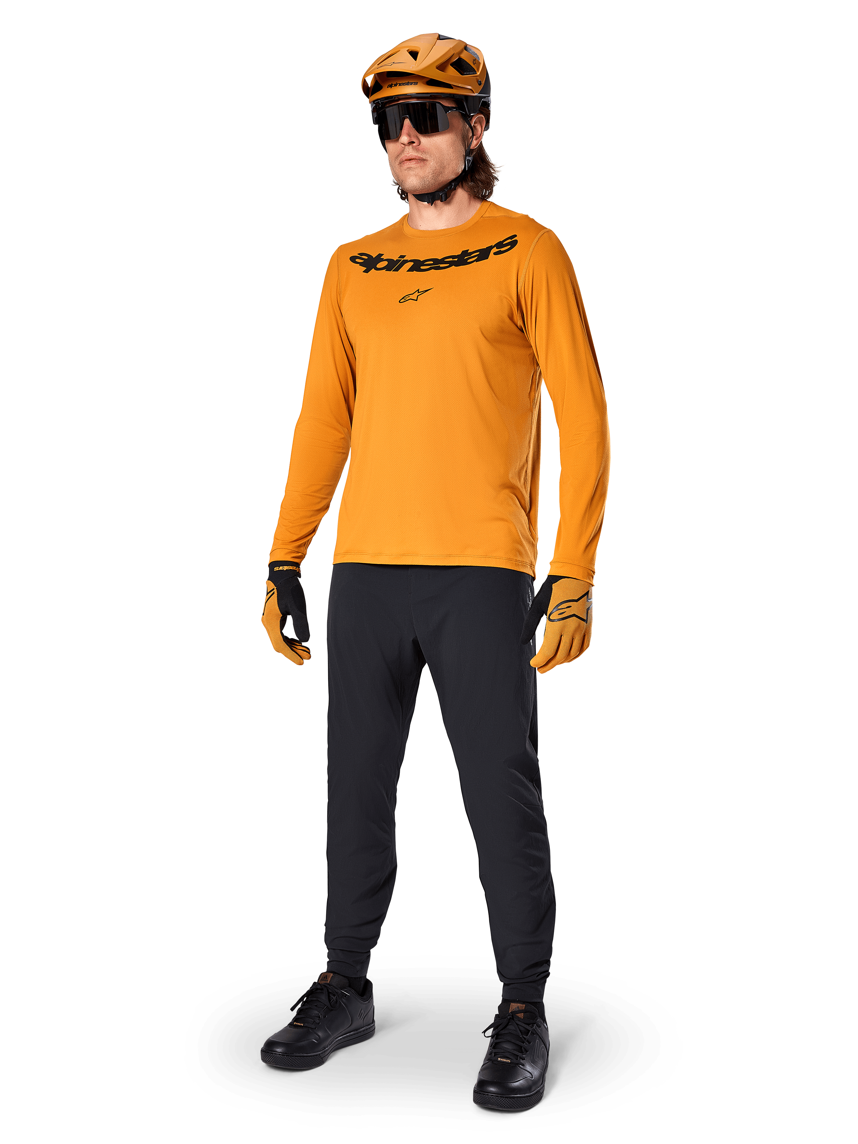 Alpinestars A-Dura Rocker Long Sleeve Jersey, Dark Gold cycling jersey, worn with matching MTB helmet and black pants, featuring black wordmark chest logo, coordinated performance gear for off-road mountain biking