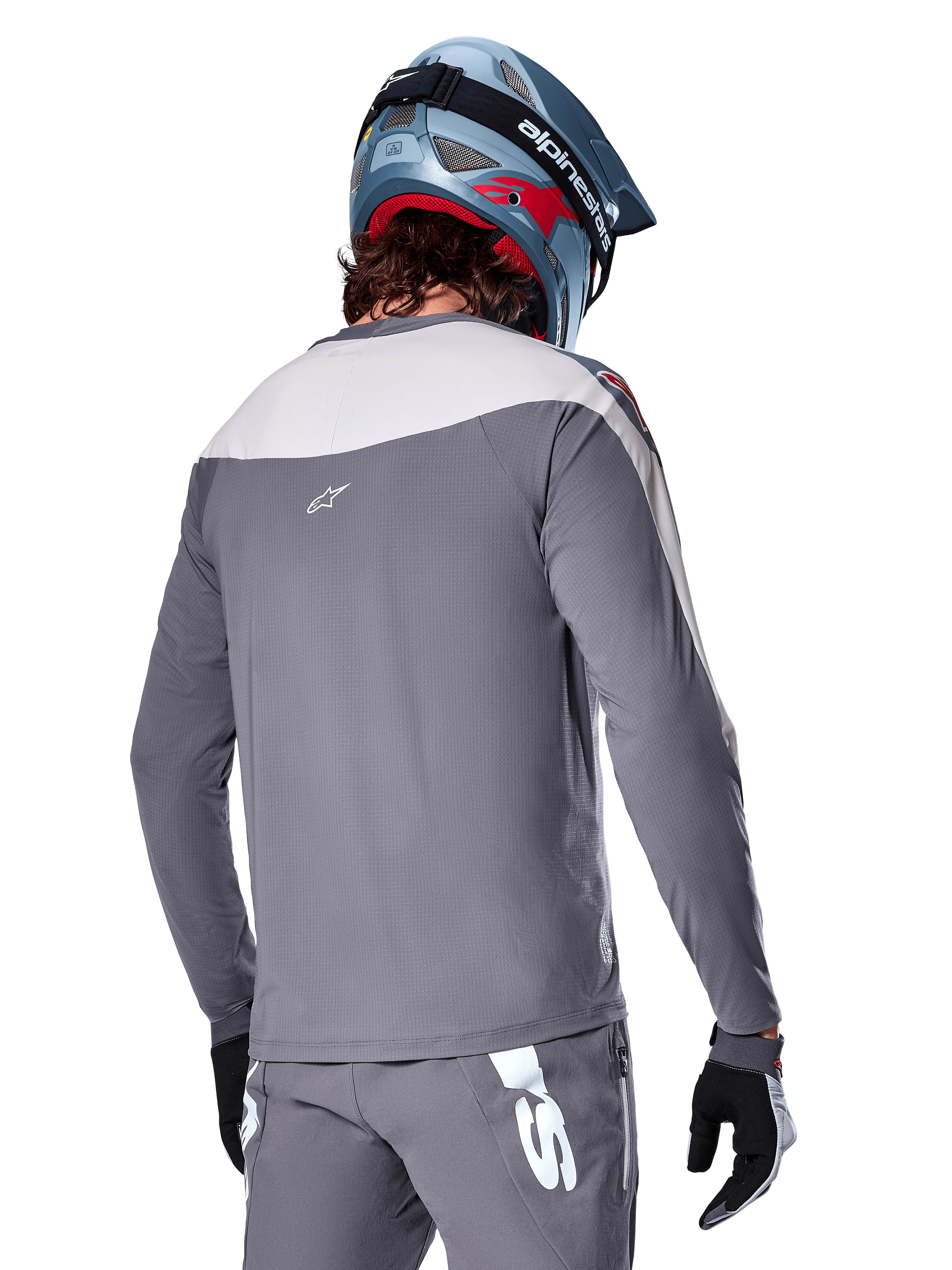 Alpinestars A-Supra Race Jersey, Long Sleeve MTB Jersey in Dark Gray and light gray, back view showing performance fit and Astar logo, worn with matching gray pants and a blue mountain bike helmet, engineered for off-road mountain biking.