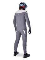 Alpinestars A-Supra Race Jersey, Long Sleeve MTB Jersey, Dark Gray with light gray shoulder panel, back view worn with matching pants, blue and red full-face helmet, black gloves and shoes, racing-inspired performance cycling gear