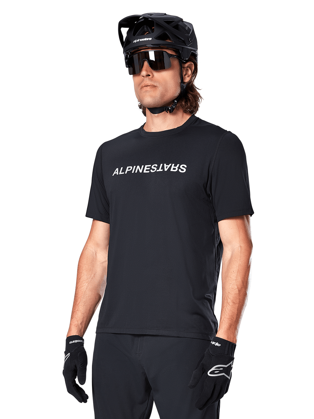 Alpinestars A-Dura Switch Short Sleeve Jersey, Black, featuring a white wordmark logo on the chest, worn by a cyclist with a black MTB helmet and sunglasses, technical apparel designed for trail riding