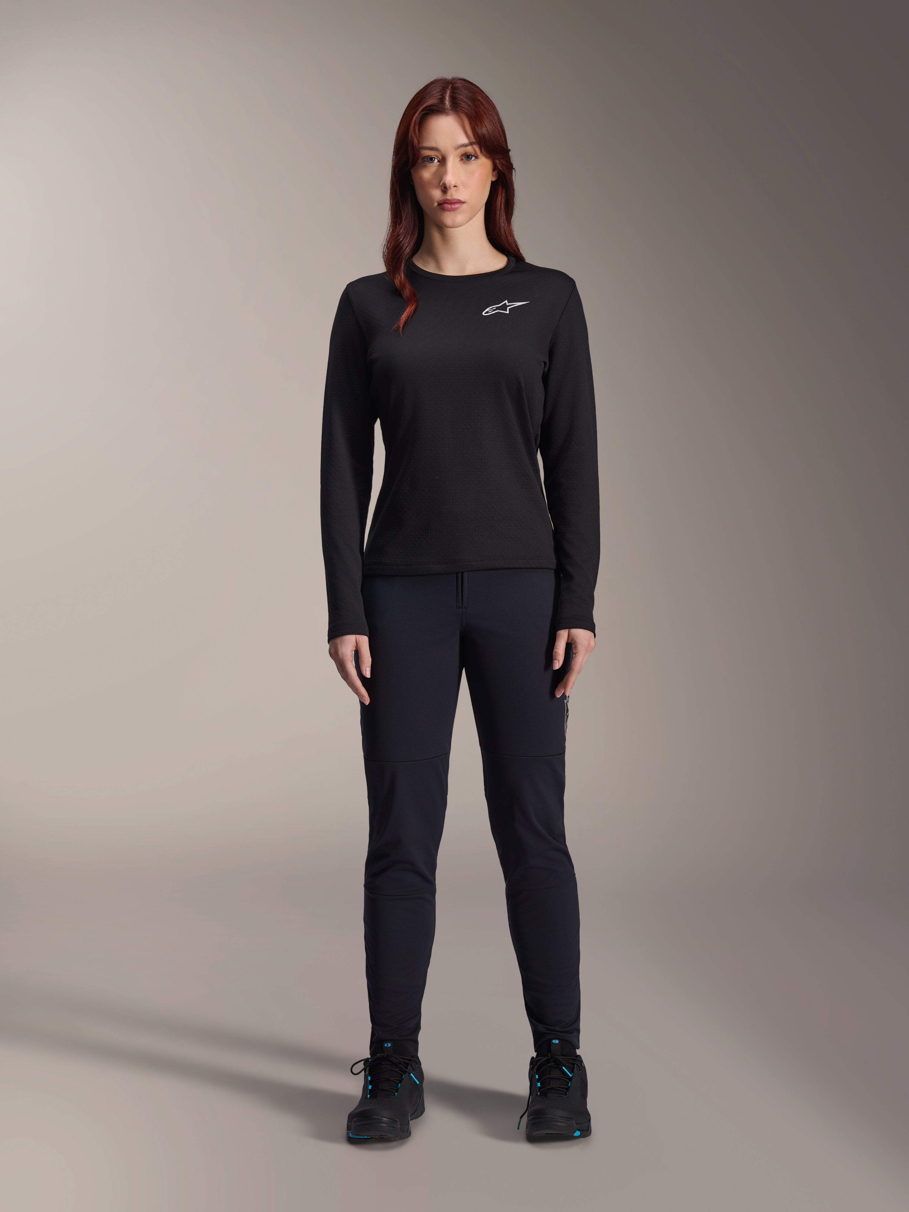 Alpinestars Stella A-Dura Thermal Jersey, Woman's Long-Sleeve Mountain Bike Jersey in Black, featuring a white chest logo, worn with matching black gear and cycling shoes, studio portrait.