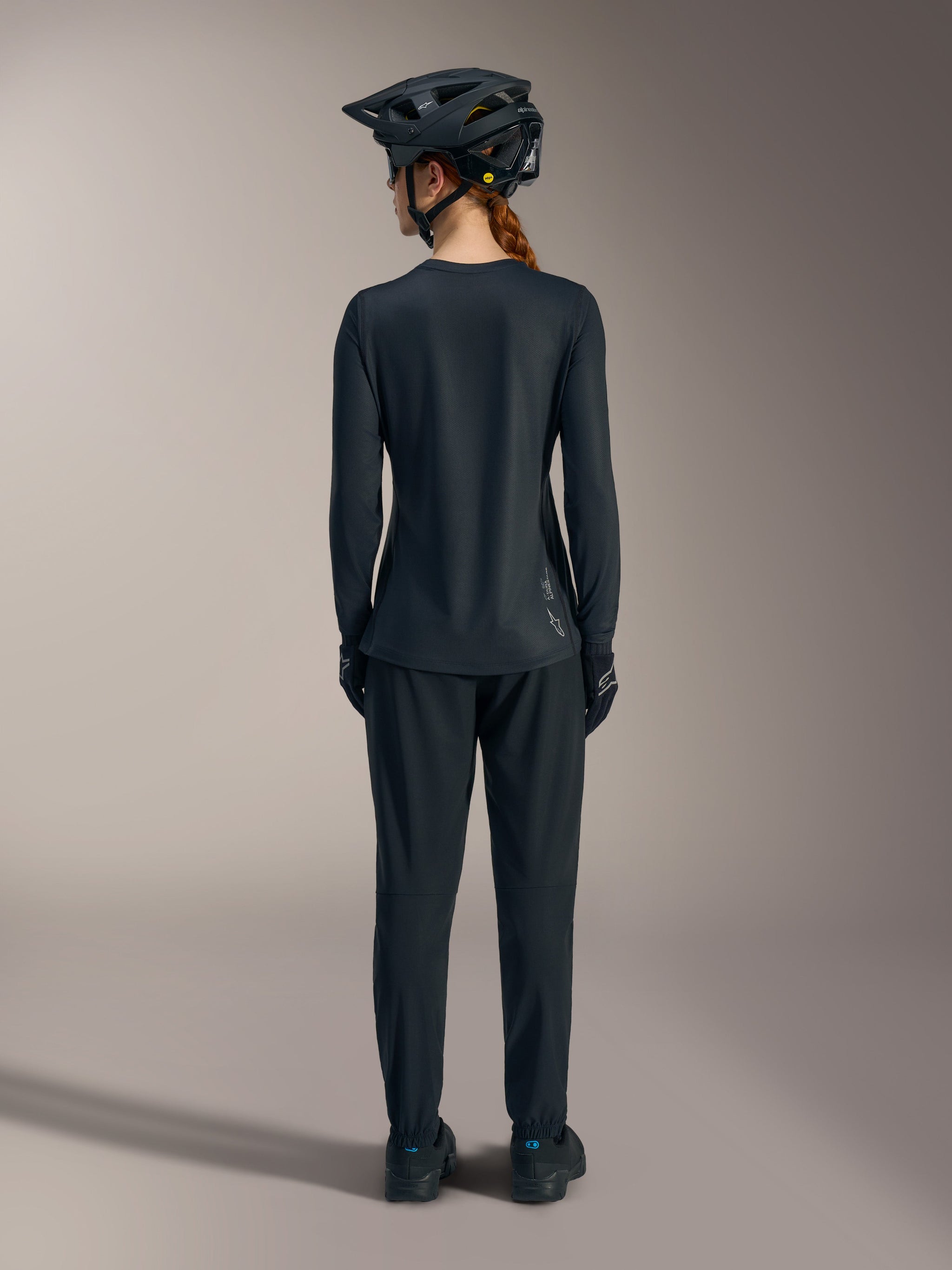 Women’s black Stella A-Dura Ride Long Sleeve MTB Jersey, back view featuring a dropped tail and white Alpinestars logo.