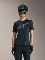 Black Women's Stella A-Dura Ride Jersey featuring a grey chest logo, styled with a mountain bike helmet and goggles.