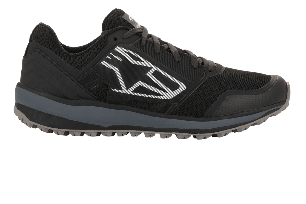 Alpinestars Meta Trail Shoes, Performance Running Shoes, Black and Dark Gray, side profile featuring a large white geometric Astars logo, mesh upper with gray midsole and lugged rubber sole, casual motorsport paddock footwear