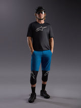 Alpinestars A-Dura Ride SS Jersey and blue shorts, complete mountain bike outfit with protective pads and helmet.