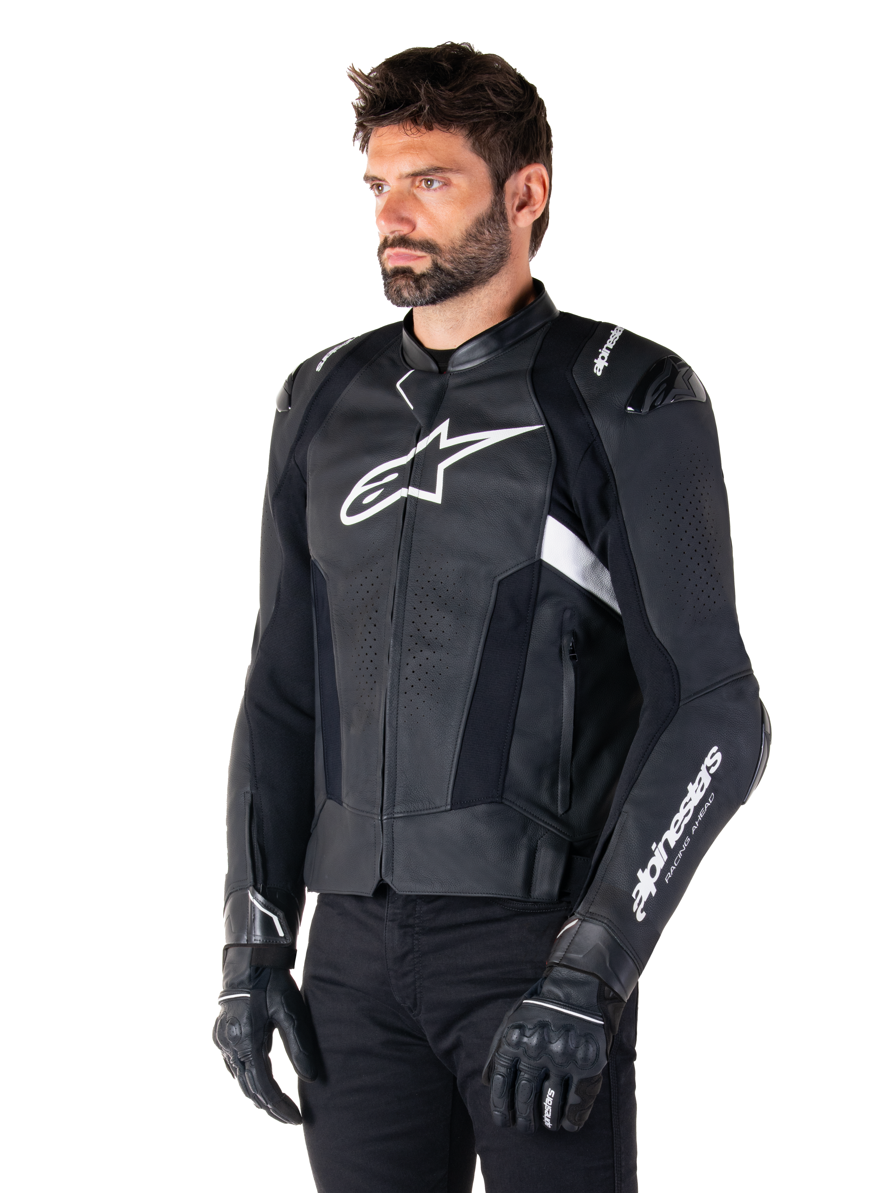 Alpinestars Missile V3 Leather Jacket, Black and White, worn by a man with black riding gloves, featuring a prominent white Alpinestars logo on the chest, external shoulder sliders, and perforated panels for a racing-inspired look.