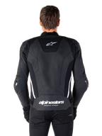 Rear view of the Alpinestars Missile V3 Leather Jacket in Black and White, featuring the Alpinestars star logo on the upper back and branding on the lower lumbar, white vertical stripes, and external elbow sliders, premium leather racing sport jacket.