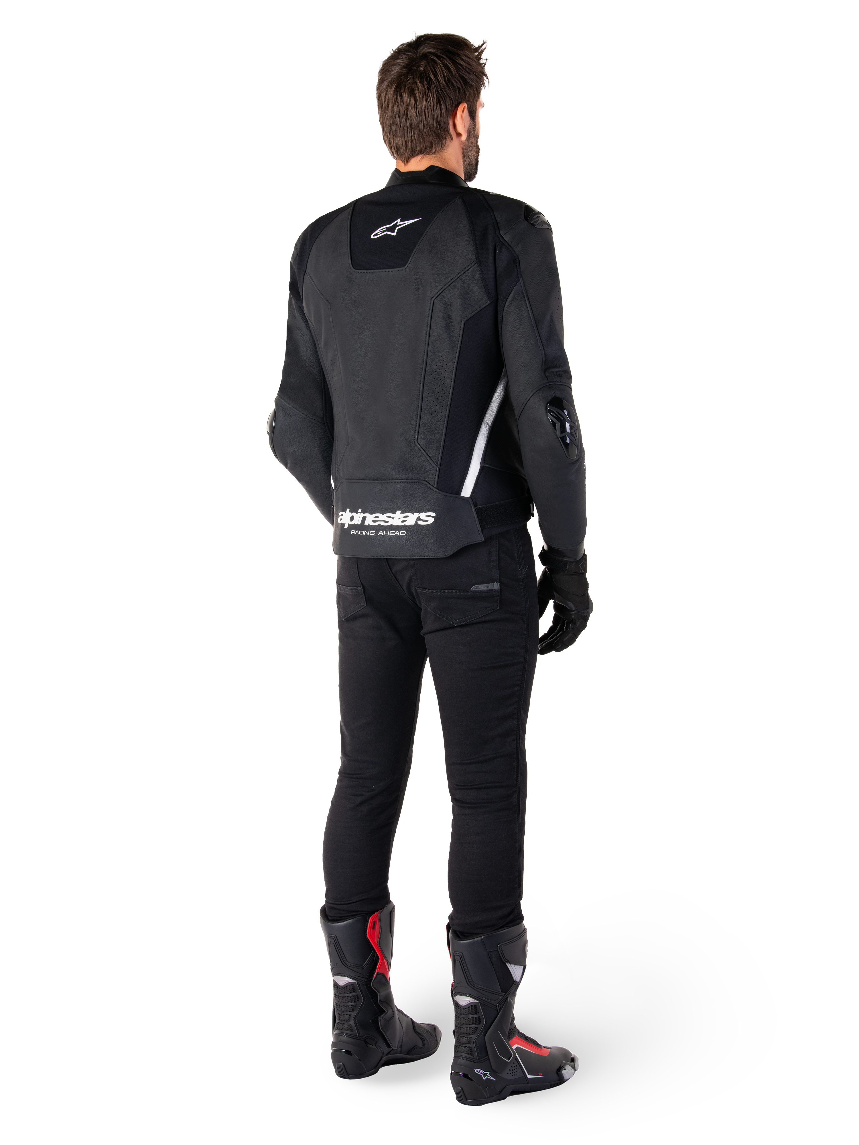 Alpinestars Missile V3 Leather Jacket, Black and White, rear view on rider, featuring bold white Alpinestars branding on the lower back and small logo on the upper back, worn with black pants and racing boots, premium leather construction for motorcycle racing