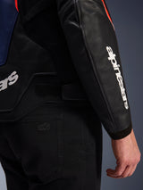 Alpinestars GP Force V2 Leather Jacket, Black Blue and Red Fluo, close-up of sleeve with white Alpinestars logo, adjustable waist strap, and premium leather construction, styled with black motorcycle pants