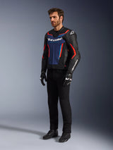 Model wearing the Alpinestars GP Force V2 Leather Jacket in Black Blue Red Fluo, paired with black technical riding pants, black gloves, and boots, professional motorcycle racing gear for sport riding