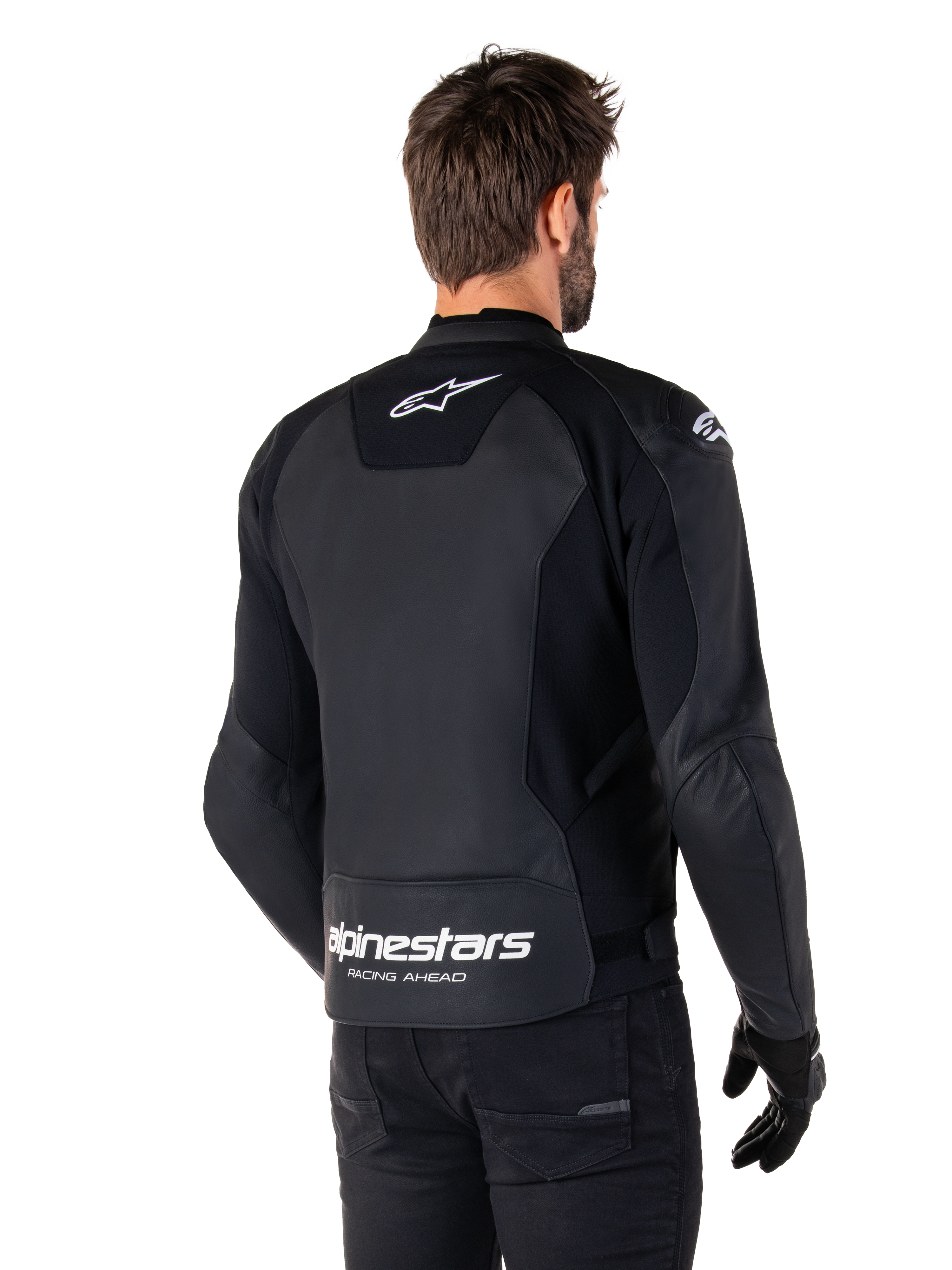 Alpinestars Faster V3 Leather Jacket, Black and White, rear view on a rider, featuring white star logo on the upper back and large Alpinestars branding with "Racing Ahead" on the lower tail, elongated rear for riding coverage, premium sport leather construction