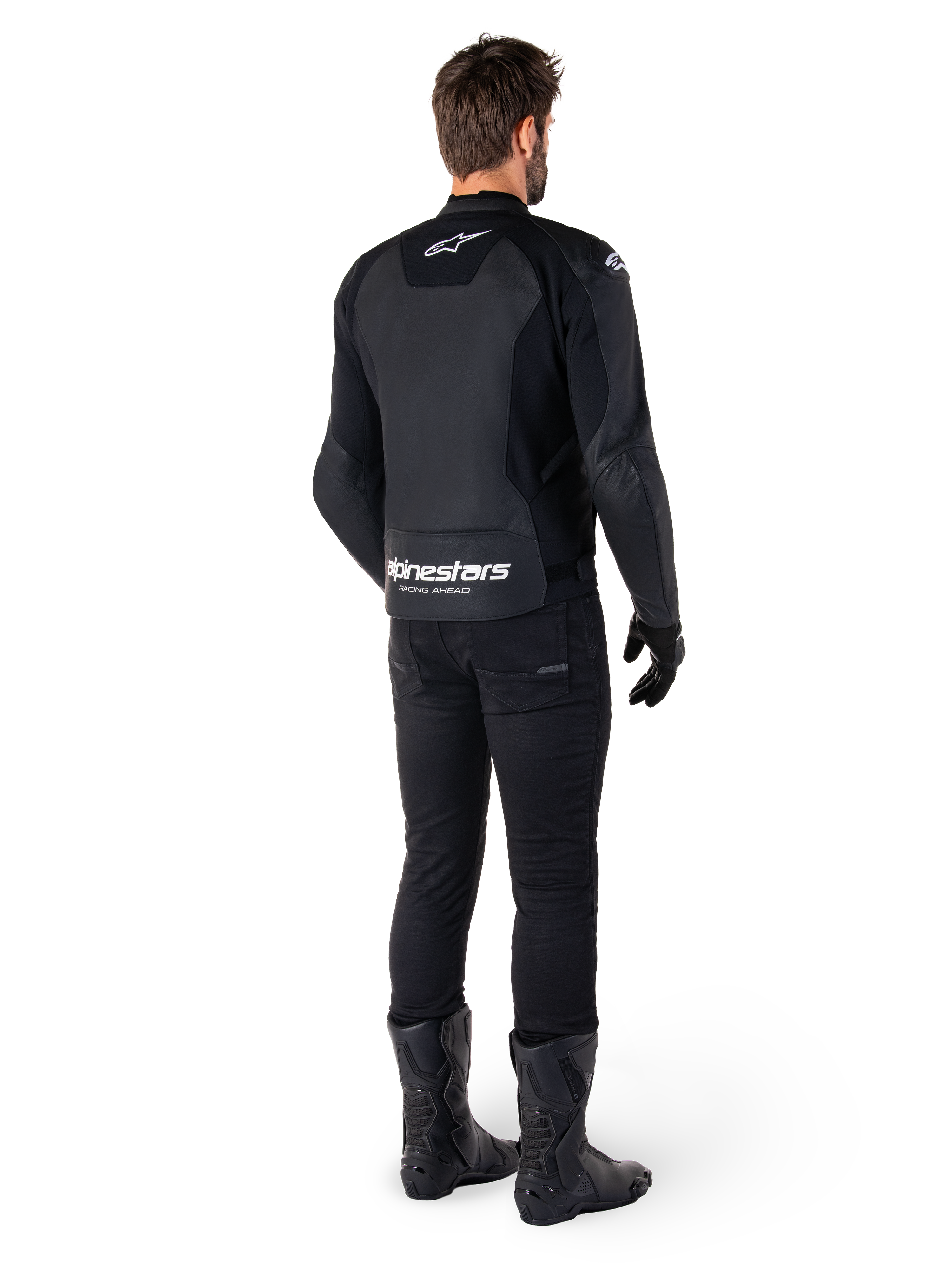 Alpinestars Faster V3 Leather Jacket, Rear View, Black and White, featuring 'alpinestars RACING AHEAD' branding on the lower back, worn with black riding pants and boots, sport-derived leather motorcycle jacket with stretch panels.