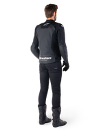 Alpinestars Faster V3 Airflow Leather Jacket, Black and White, rear view showing perforated leather panels and prominent Alpinestars branding on the lower back, worn by a rider with black riding pants, gloves, and boots.