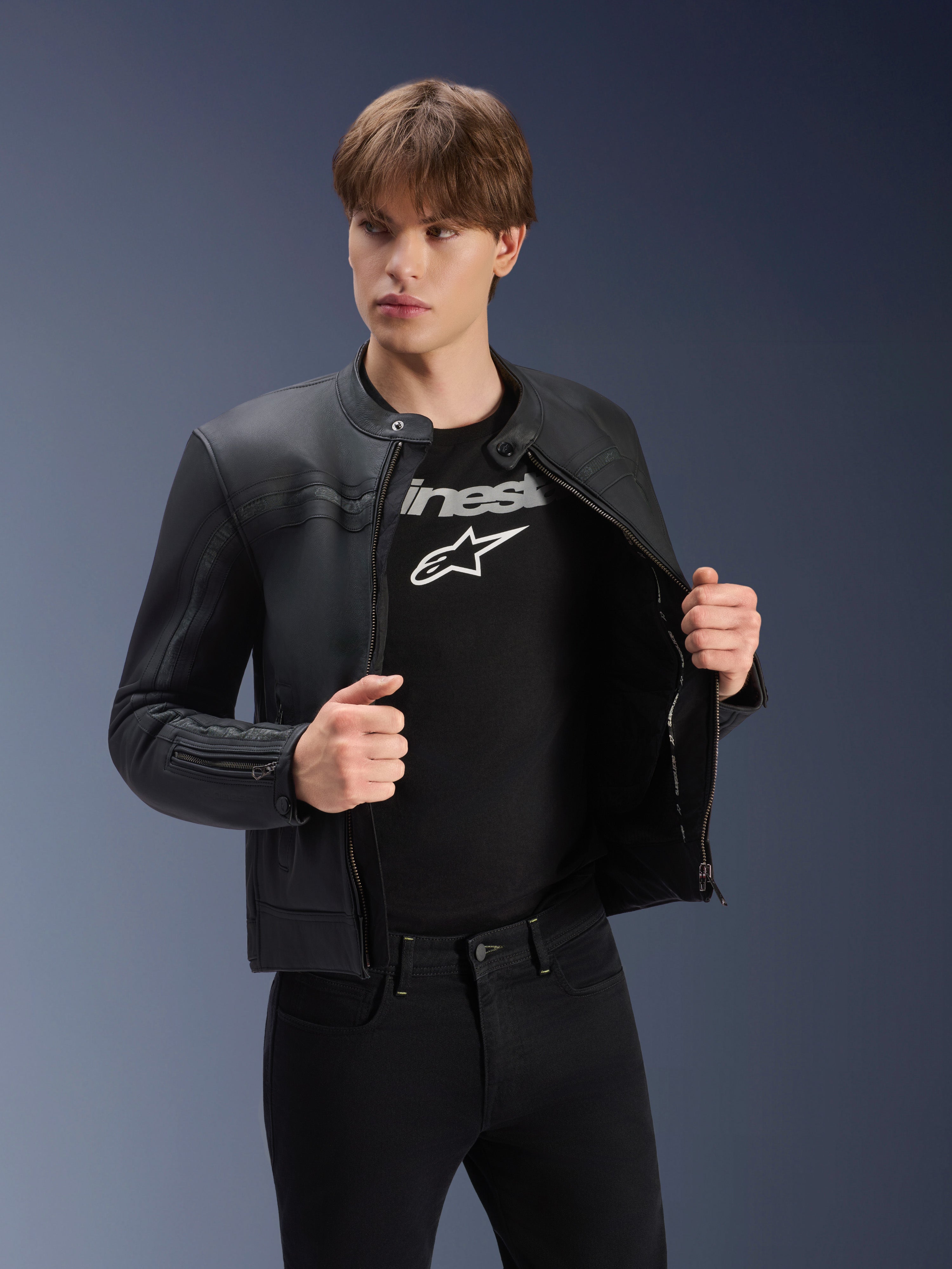 Alpinestars Dyno Leather Jacket, Black, worn by a male model over a black logo t-shirt, premium bovine leather motorcycle jacket with a heritage-inspired design, featuring subtle chest stripes and a contemporary urban fit.