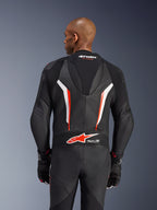 Alpinestars GP Force V2 Leather Suit, 1-Piece Motorcycle Suit, Black White and Red Fluo, back view of upper body showing perforated leather and Tech-Air Ready logo, worn with matching black and red gloves