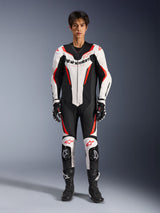 Alpinestars GP Force V2 Leather Suit - 1Piece, White Black Red Fluo, one-piece leather motorcycle racing suit, front view on model, featuring perforated panels and red accents, bold Alpinestars branding on chest, styled with professional racing boots and gloves