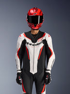 Alpinestars GP Force V2 Leather Suit - 1Piece, White Black Red Fluo, worn with red full-face helmet and black racing gloves, featuring perforated leather panels and bold Alpinestars branding on the chest, professional performance gear for motorcycle racing
