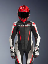 Female rider wearing Alpinestars Stella GP-R7 2-Piece Leather Suit, Black White and Red Fluo colors, featuring perforated panels and 'Racing Ahead' branding, worn with a red helmet and white/black GP Pro gloves, professional racing gear setup