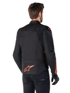 Male model wearing the Alpinestars T-Jaws V4 Waterproof Jacket from the back, Black with Red Fluo accents, featuring a red fluo logo on the lower back and accents on the shoulders and sleeves, sport motorcycle riding gear.