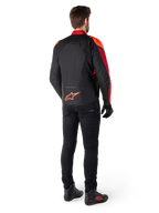Alpinestars T-Jaws V4 Waterproof Jacket in Black Red Fluo Dark Red, rear view of a rider wearing the textile jacket with black pants and riding boots, featuring a bold red Alpinestars logo on the lower back.