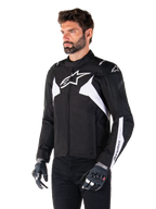 Alpinestars T-Jaws V4 Waterproof Jacket, Black and White, worn by a model with motorcycle gloves, featuring prominent white Alpinestars logos and accents, sport-fit textile motorcycle jacket for road riding