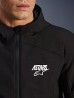 Alpinestars Aeroshell Waterproof Jacket, black motorcycle softshell jacket, close-up view of the chest featuring a white ASTARS star logo and waterproof front zipper, integrated hood, modern sport-styled design