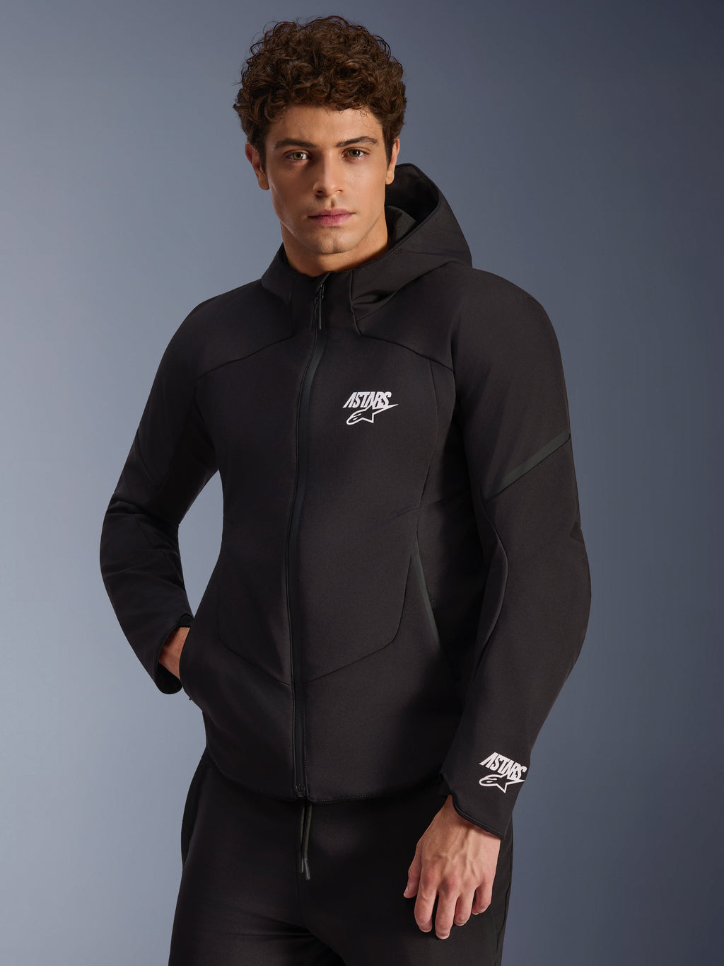 Alpinestars Aeroshell Waterproof Jacket, Black softshell motorcycle hoodie, white ASTARS logo on chest and cuff, sleek design with integrated hood and waterproof zipper, modern sport-inspired gear for urban riding