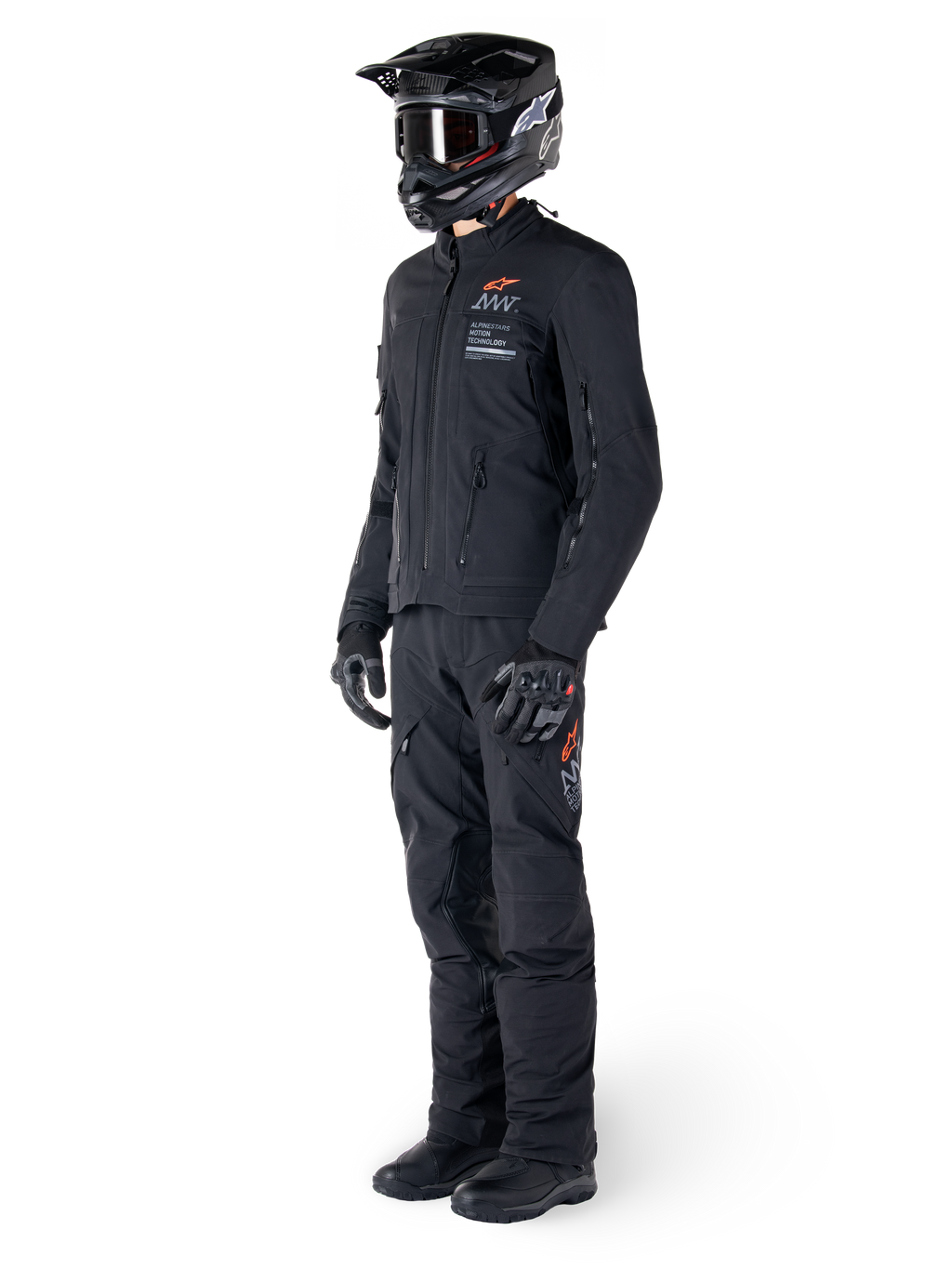Alpinestars AMT-8 Stretch Drystar® XF Jacket, Adventure Motorcycle Jacket, Black, worn with matching pants, helmet, and gloves, featuring Alpinestars Motion Technology branding with orange accents, durable stretch construction for adventure riding