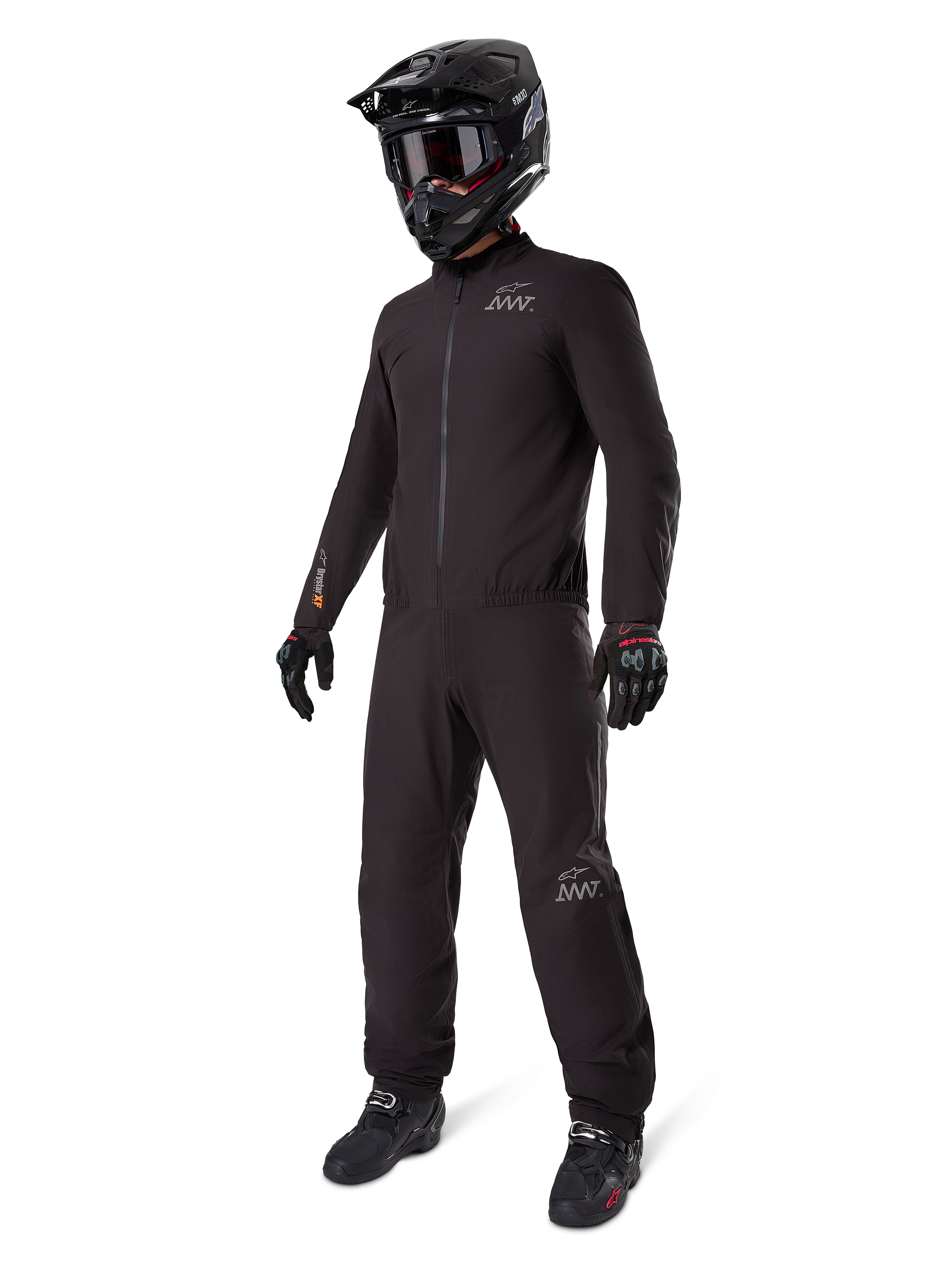Alpinestars AMT-8 Stretch Drystar® XF Liner, black waterproof motorcycle suit, worn with black helmet, goggles, and gloves, featuring AMT and Drystar XF branding, functional adventure gear for all-weather protection.