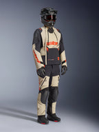 Alpinestars Halo Pro Drystar® XF Laminated Jacket in Mastic Black, adventure motorcycle jacket worn with matching pants, full-face helmet, gloves, and boots, featuring tan and black panels with red logos, technical multi-season design.