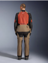 Alpinestars Andes V4 Drystar® Jacket, Walnut Rust Black, rear view of motorcycle touring jacket featuring rust-colored upper back panel and walnut lower section, worn with matching adventure pants and black boots