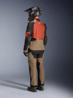 Alpinestars Andes V4 Drystar® Jacket, Walnut Rust Black colorway, back view of a rider wearing matching adventure pants, black helmet, and black riding boots, technical textile motorcycle gear for all-weather adventure touring.