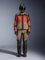 Adventure rider wearing the Alpinestars Andes V4 Drystar® Jacket in Walnut Rust Black, styled with matching adventure pants, a black helmet with red accents and goggles, and black gloves, showcasing a complete all-weather touring outfit.