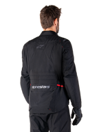 Alpinestars ST-1 Waterproof Jacket, Black, rear view on a model, featuring Alpinestars branding on the lower back cargo pocket, subtle red accents, textile adventure touring motorcycle jacket